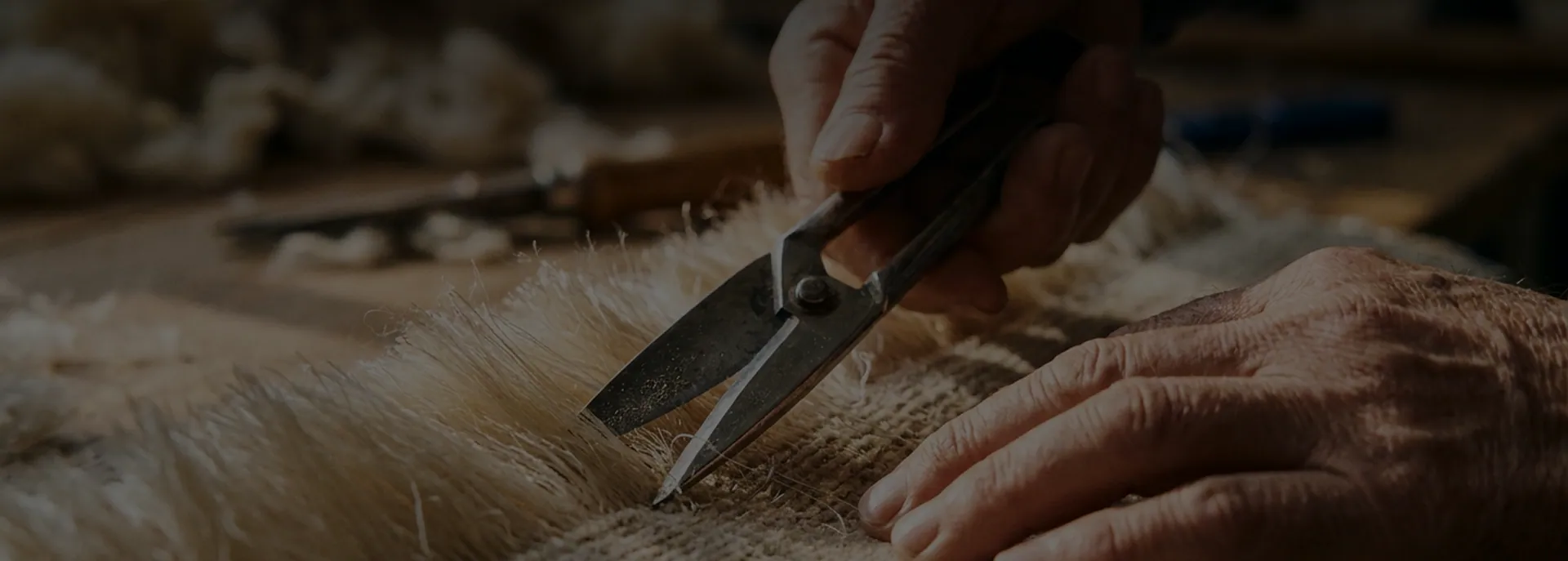 Hands trimming the pile of a handmade rug