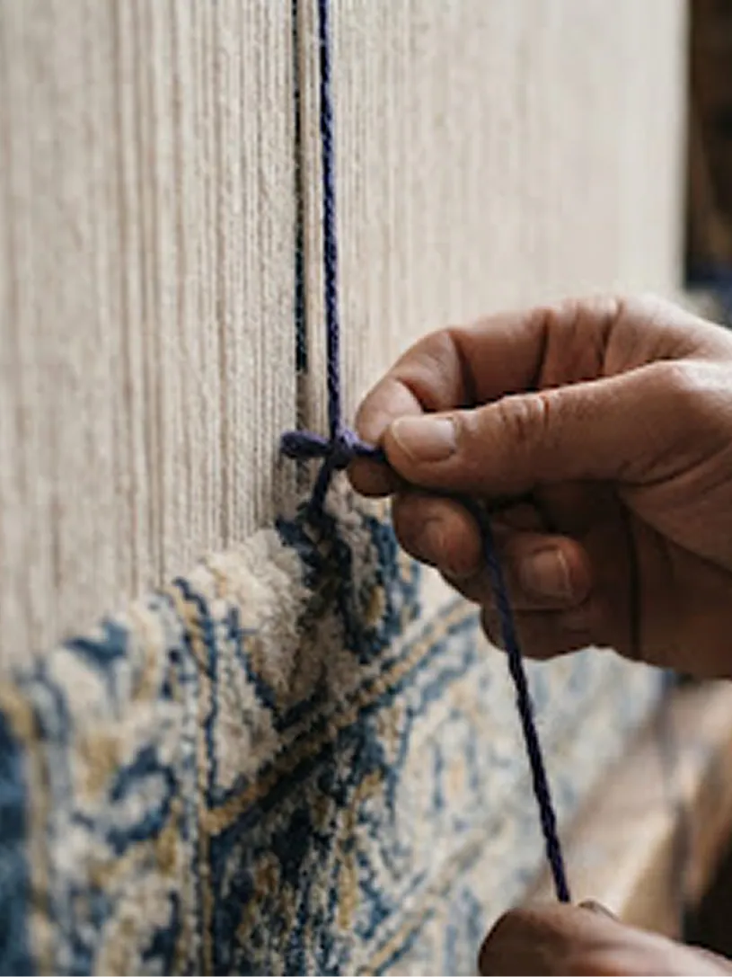 A weaver tying a single indigo knot onto the warp