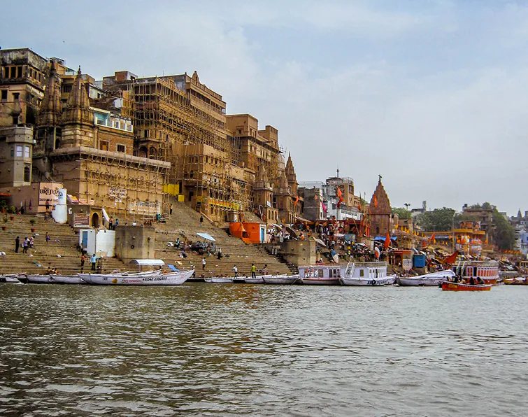 The ghats of Varanasi at dawn, boats moored along the riverfront
