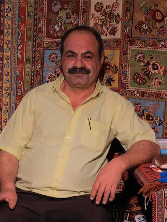 Kabir seated before a patterned rug